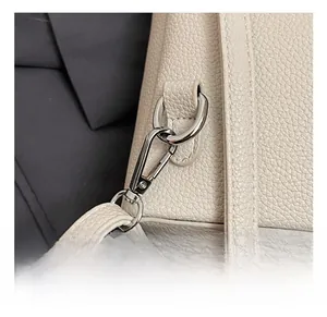 Detail of silver metal hook and D-ring on cream lychee pattern leather shoulder bag
