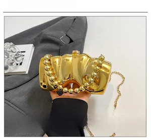 Détail du sac de soirée doré irrégulier avec poignée en perles et bandoulière chaîne