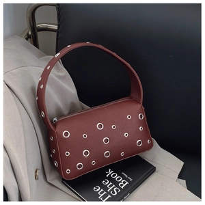 Detailed macro view of burgundy pebbled leather surface with silver metal eyelet grommets