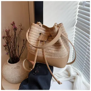 Detail of woven straw bucket bag with leather base and elegant drawstring closure