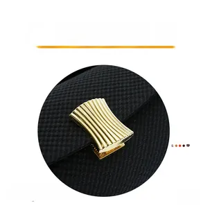 Detail of elegant gold wavy metal buckle on black textured handbag with vertical grain
