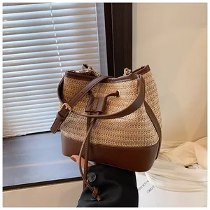 Detail of woven bucket bag with brown leather drawstring closure and textured fiber