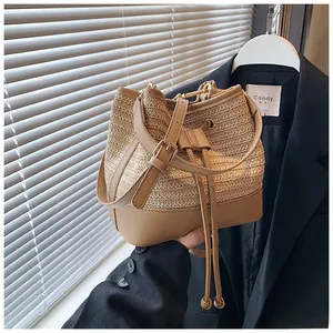 Detail of woven straw bucket bag with leather drawstring and adjustable shoulder strap