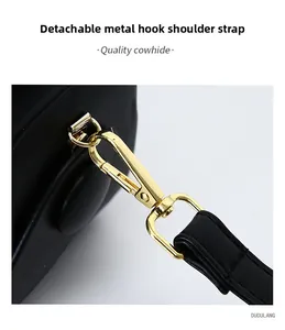 Detail of the golden metal hook and detachable cowhide leather strap on a black bag