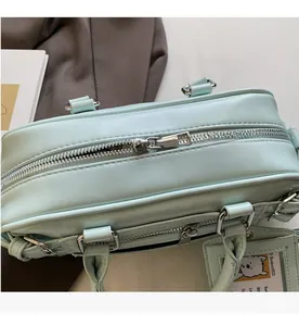 Detail shot of smooth silver dual zippers and mint green leather handbag texture