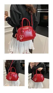 Detail of red glossy tote bag with heart charm and side pockets for women