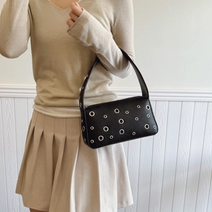 Chic black underarm bag in pebble leather with silver eyelet studs on casual shoulder bag