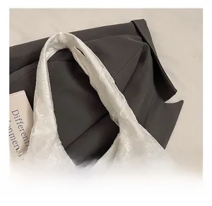 Macro detail of white tote bag featuring 3D textured pattern and premium wide handle