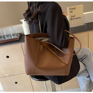 Détail d'un grand sac cabas marron avec de fines bandoulières pour le quotidien