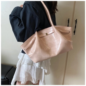Detail of light pink pleated tote bag with glossy finish and gold metal buckle detail