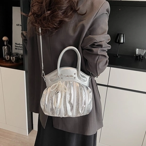 Silver metallic ruched motorcycle handbag with heart pearl charm shown on a model