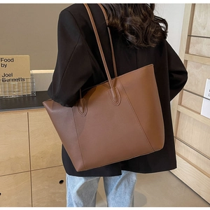 Détail du grand sac cabas marron avec coutures précises et longues bretelles d'épaule