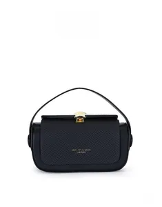 Detail of black box bag featuring a golden shell-shaped clasp and textured fabric