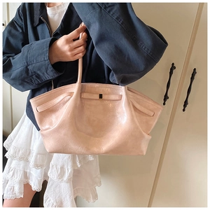 Detailed view of large pink tote bag featuring unique pleated texture and metal buckle