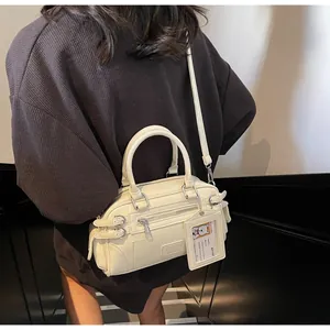 Close-up of cream Boston handbag with retro biker zippers and adjustable side buckles