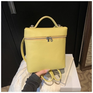 Detail of a bright yellow litchi texture leather backpack with silver zippers