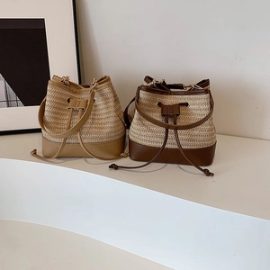 Handwoven straw bucket bag with leather trim for beach vacations and summer crossbody use