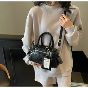 Detail of black Boston crossbody bag featuring buckle straps and transparent card charm