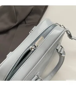Detail view of smooth silver zipper and fine leather texture on light blue tote bag