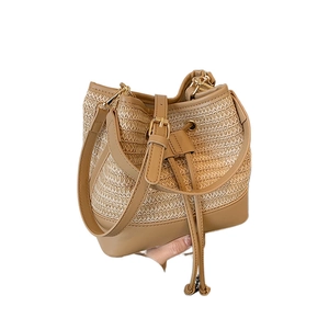 Woven straw bucket bag with khaki leather trim and adjustable strap for summer beach holidays