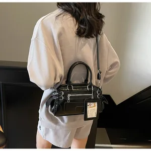Street style retro black leather crossbody bag with zippers shown on a model