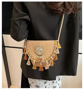 Close-up of bohemian straw crossbody bag featuring colorful tassels and beadwork