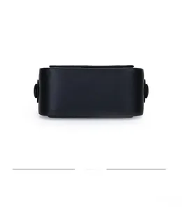 Detailed bottom view of a minimalist black smooth leather box bag with round buckles