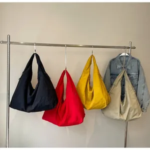 Detail van grote nylon halve maan tassen in vier trendy en minimalistische kleuren