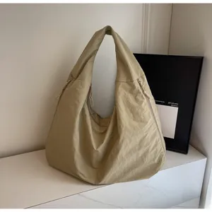 Detail van kaki nylon draagtas met gestructureerde stof en verstelbare trekkoordsluiting