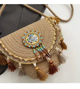 Close-up of straw woven bag with colorful tassels, beads and ethnic totem emblem