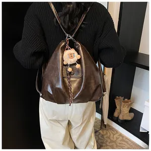 Retro dark brown PU leather backpack with cute plush sheep charm shown on a model