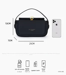 Detail view of woven black crossbody bag with golden shell clasp and size reference