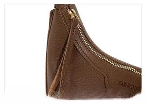 Nahaufnahme der braunen Ledertasche mit Litschi-Muster, Goldzipper und Logo