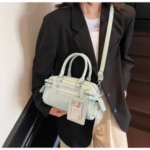 Detail of light mint green mini boston bag with silver hardware and cartoon charm