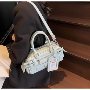 Detailed view of mint green moto-style crossbody bag with multi-zippers and long straps