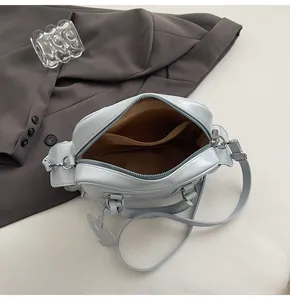 Detail of light blue leather tote bag with heart charm and interior lining