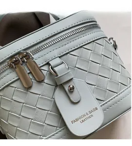 Detail der mintgrünen gewebten Ledertasche mit zwei Metall-Reißverschlüssen und feiner Struktur