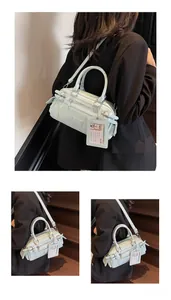 Detail view of mint green Boston bag with multiple zipper pockets and detachable strap
