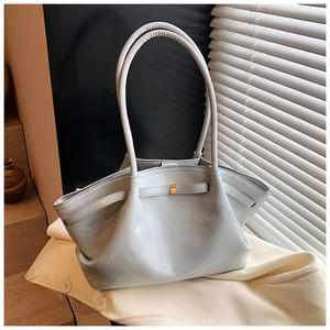 Close-up of light blue pleated tote bag with fine leather texture and golden metal buckle