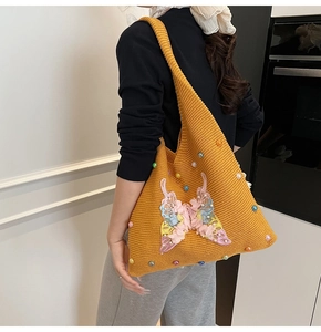 Détail du sac cabas en tricot jaune avec broderie papillon 3D et perles décoratives