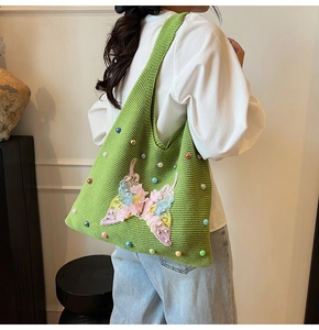 Détail du sac cabas tricoté vert herbe avec perles colorées et applique de papillon