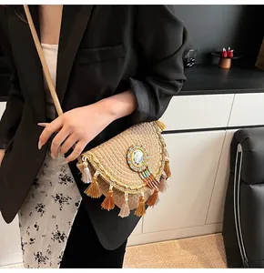 Detail of straw crossbody bag showing layered fringe and colorful beadwork embroidery