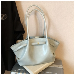 Detail of light blue pleated tote bag with glossy finish and delicate gold buckle