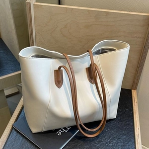 Grand sac fourre-tout blanc avec anses marron sur chaise en bois, style épuré et chic