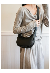 Detailansicht einer schwarzen Halbmond-Tasche aus Leder mit feiner Litschi-Struktur