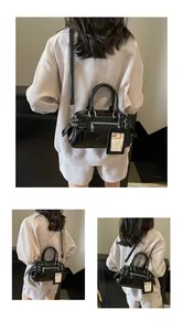 Detail of black vintage Boston bag with multiple functional zippers and long strap