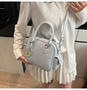 Close-up of light blue structured tote bag with matte leather finish and heart charm