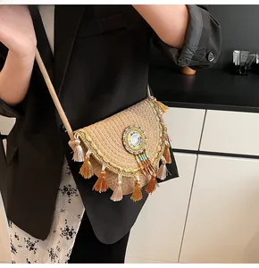 Detail of straw woven crossbody bag featuring fringe tassels and colorful bead accents