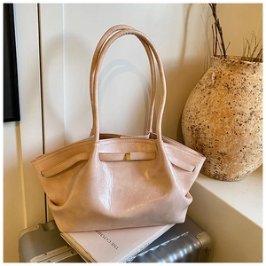Detail of light pink patent leather tote bag with pleated texture and gold buckle hardware