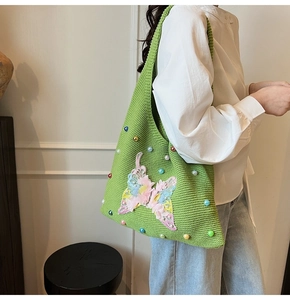 Détail du sac cabas en tricot vert avec broderie papillon 3D et décorations en perles
